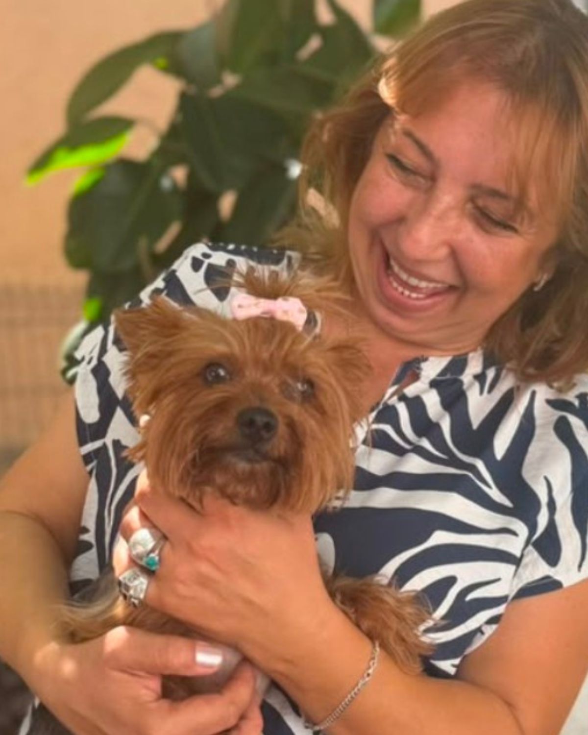 Dog expert Nataša Miranović smiling while holding and looking at her Yorkshire Terrier.